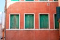 Red facade with three weathered green window