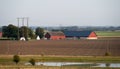 Red farm buildings and barns in the middle of the flat farmlands of SkÃÂ¥ne Scania during summer in Sweden