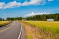 Red farm with the road, blue sky and green field Royalty Free Stock Photo