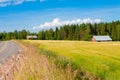 Red farm with the road, blue sky and green field Royalty Free Stock Photo