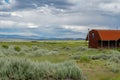 Red farm shed in a big grassland farm field Royalty Free Stock Photo