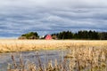 Red farmhouse with a barn, a car and a truck at the edge of a gr Royalty Free Stock Photo