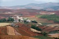 Red farmland with village in dongchuan of china Royalty Free Stock Photo