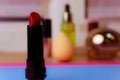 Red fashionable lipour lipad, and highlighter on the background of a beauty makeup table Royalty Free Stock Photo