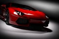 Red fast sports car in spotlight, black background. Shiny, new, luxurious. Royalty Free Stock Photo