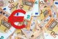 Red felt Euro currency sign on 50 fifty euro banknotes background, place for text.
