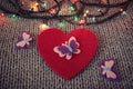 Red felt heart, colorful garland with woollen texture in the background