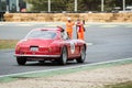 Red Ferrari 250 GT Berlinetta with the driver on the right side relaxed and the stewards applauding after crossing the finish lin