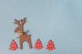 Red festive christmas hand made toys over the blue background with copy space for text and xmas decoration.Wooden deer