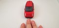 Red Fiat 500 toy car driving over female fingers Royalty Free Stock Photo