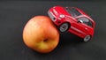 Red Fiat 500 toy model stands up on peach fruit Royalty Free Stock Photo