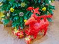 Red figurine of a deer and boxes with gifts stand under the christmas tree Royalty Free Stock Photo