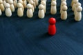 Red figurine in front of line as symbol of leadership. Stand out from the crowd