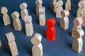 Red figurine of a man in a crowd of people. Stranger, eye-catching. Different, special. Infected carrying threat of spread Royalty Free Stock Photo