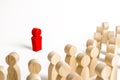 Red figurine of a man in the spotlight of a crowd of people. Leader, leadership and initiator of action. work or business