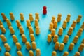 The red figurine moves through the crowd. Be a different and unique leader concept. Royalty Free Stock Photo