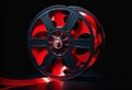 A red film reel with film strips on a dark background Royalty Free Stock Photo