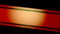 Red film strip with circular orange light on black background close up. Cinema filmstrip on black background. 35mm film Royalty Free Stock Photo