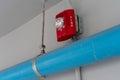 Red Fire alarm lighting above PVC pipe against white background