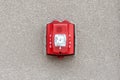 Red fire alarm siren with flashing light strobe isolated on gray cement wall outdoor. Fire safety.