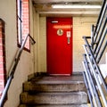 Red Fire Door At The Top Of A Concrete Stairway