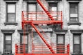 Red fire escape at black and white filtered residential building Royalty Free Stock Photo