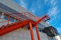 Red fire escape on the facade of the building against a bright blue sky Royalty Free Stock Photo