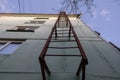 Red fire escape on the facade of a residential building. Royalty Free Stock Photo