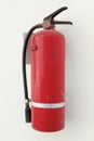 Red fire extinguisher canister on white wall