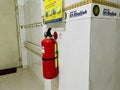 A red fire extinguisher is mounted on a white tiled wall. Royalty Free Stock Photo