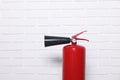 Red fire extinguisher near white brick wall, space for text Royalty Free Stock Photo