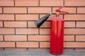 Red fire extinguisher with a small trumpet stands