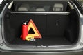 Red fire extinguisher, towing strap and foldable emergency warning triangle in trunk, space for text. Car safety Royalty Free Stock Photo