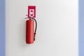 Red Fire extinguisher on the white wall background Royalty Free Stock Photo