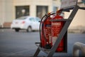 Red fire extinguishers in a stand in a petrol pump station with Arabic writing
