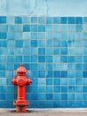 Red Fire Hydrant on Blue Tiled Wall Royalty Free Stock Photo