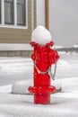 Red fire hydrant on ground with a blanket of snow