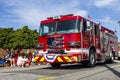 A red fire truck engine driving through the Fourth of July parade