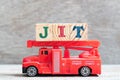 Red fire truck hold block in word JIT abbreviation of just in time on wood background Royalty Free Stock Photo