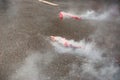 Red firecrackers exploding with smoke on the asphalt Royalty Free Stock Photo