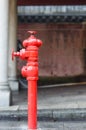 Red fireplug standing on footpath