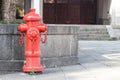 Red fireplug standing on footpath