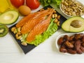 Red fish, avocado, nuts antioxidant healthy lemon protein ingredient on a wooden background Royalty Free Stock Photo