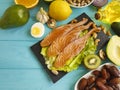 Red fish, avocado, organic nuts lemon on a blue wooden background, healthy food fresh Royalty Free Stock Photo