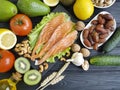 Red fish, avocado nuts selection dinner natural assorted cucumber on black wooden, healthy food Royalty Free Stock Photo