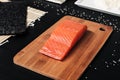 Red fish, smoked salmon on a wooden cutting board. Ingredients for rolls and sushi. Royalty Free Stock Photo