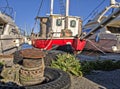 A red fishing boat moored to the dock; the rusty, metal bollard it is moored to can be seen in the foreground Royalty Free Stock Photo