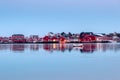 Red fishing warehouse with fishing boat reflection on coastline Royalty Free Stock Photo