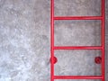Red fixed ladder on cement wall Royalty Free Stock Photo