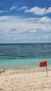 A red flag on a beach sign forbiden to swim